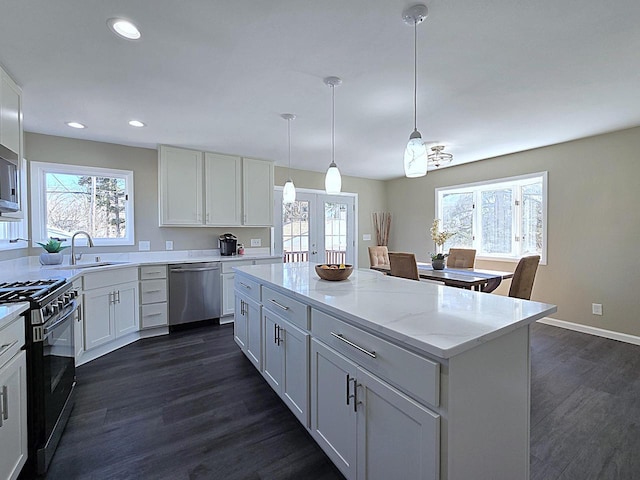 kitchen featuring a sink, a kitchen island, white cabinetry, french doors, and appliances with stainless steel finishes