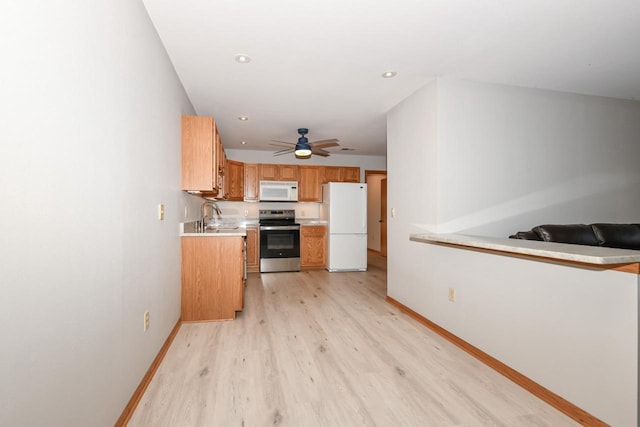 kitchen with brown cabinets, light wood finished floors, white appliances, light countertops, and baseboards