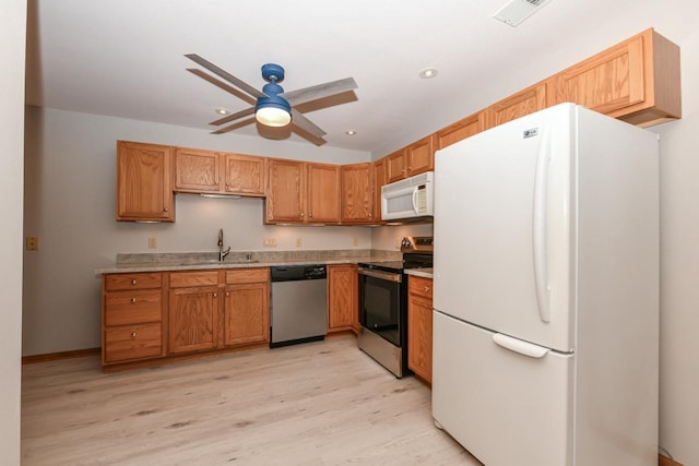 kitchen with light wood-type flooring, visible vents, a ceiling fan, stainless steel appliances, and light countertops