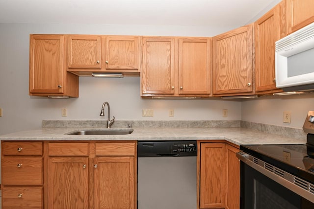 kitchen featuring appliances with stainless steel finishes, light countertops, and a sink