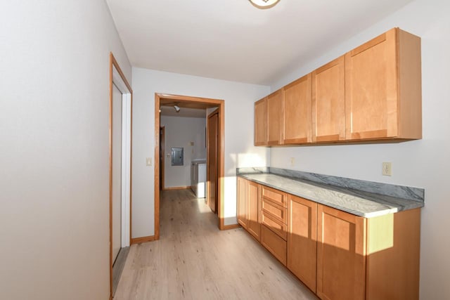 kitchen featuring light wood-type flooring, baseboards, and light countertops