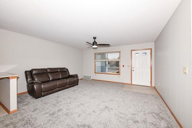 carpeted living room featuring visible vents, a ceiling fan, and baseboards