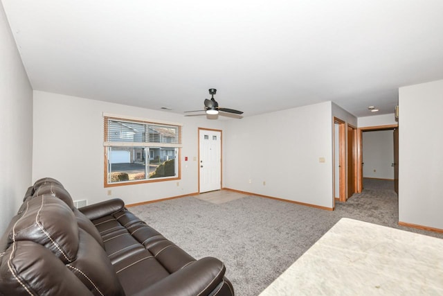 living area with a ceiling fan, carpet, and baseboards