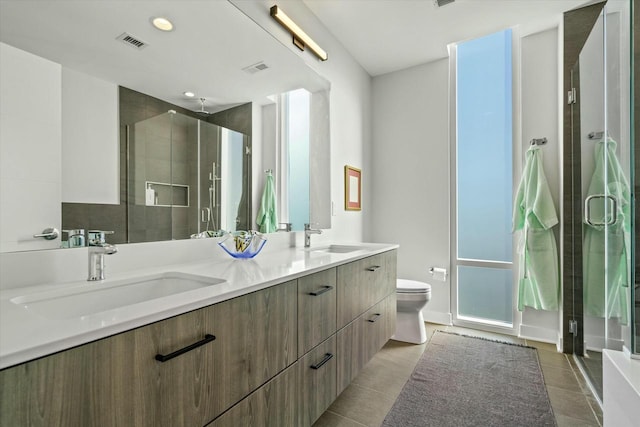 bathroom featuring a sink, visible vents, a stall shower, and tile patterned floors