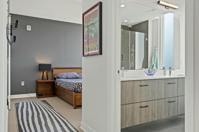 bedroom with a sink, connected bathroom, and baseboards