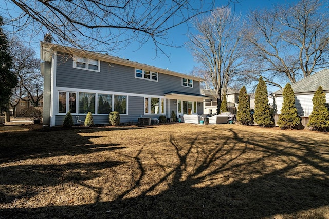 back of property featuring a lawn and a chimney