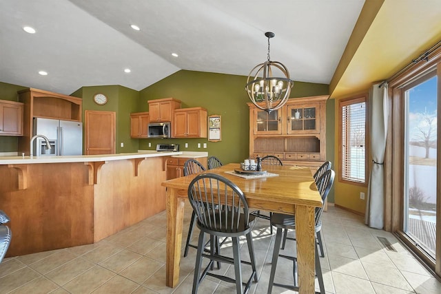 dining area featuring lofted ceiling, a notable chandelier, visible vents, and light tile patterned floors