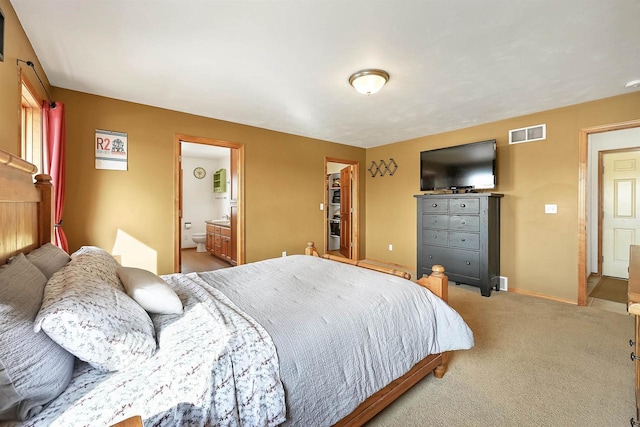 bedroom featuring baseboards, visible vents, a spacious closet, light carpet, and connected bathroom