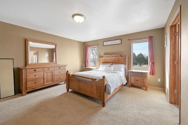 bedroom featuring light colored carpet and baseboards