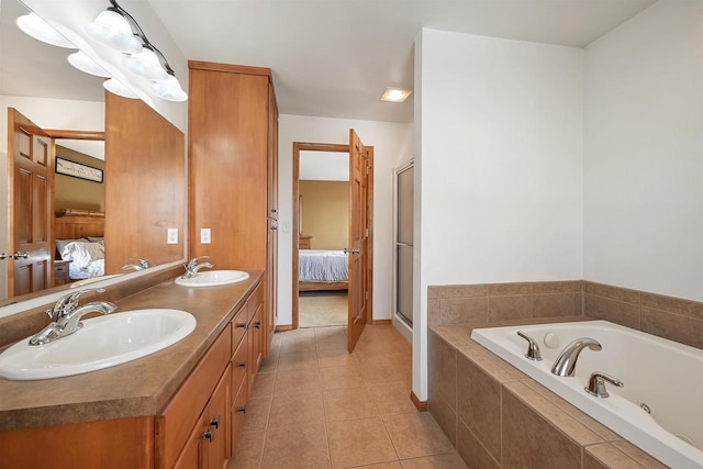 full bathroom featuring tile patterned floors, a whirlpool tub, ensuite bathroom, and a sink