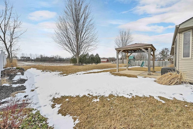 yard layered in snow with a gazebo, a patio area, and fence