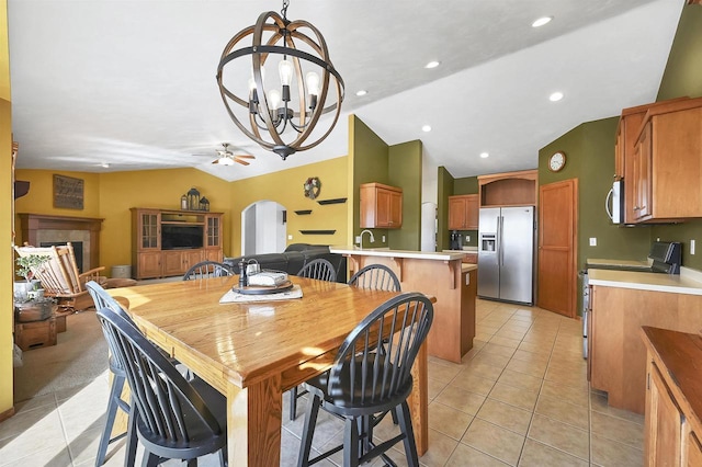 dining area featuring arched walkways, recessed lighting, light tile patterned flooring, and vaulted ceiling