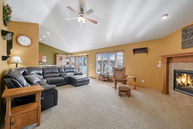 living area featuring vaulted ceiling, light carpet, recessed lighting, a tile fireplace, and a ceiling fan