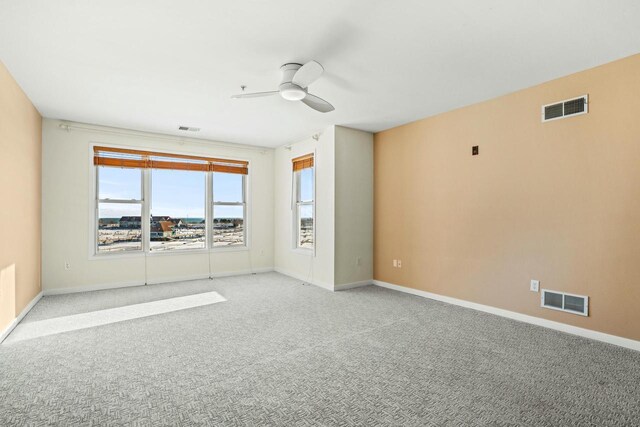 unfurnished room featuring light carpet, visible vents, and baseboards