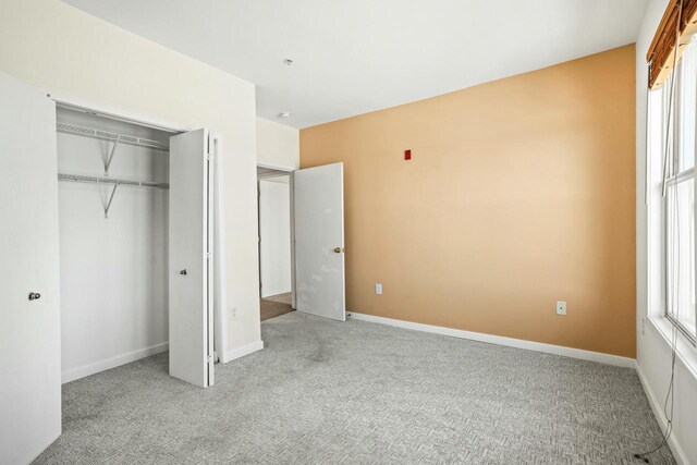 unfurnished bedroom with baseboards, a closet, and carpet floors