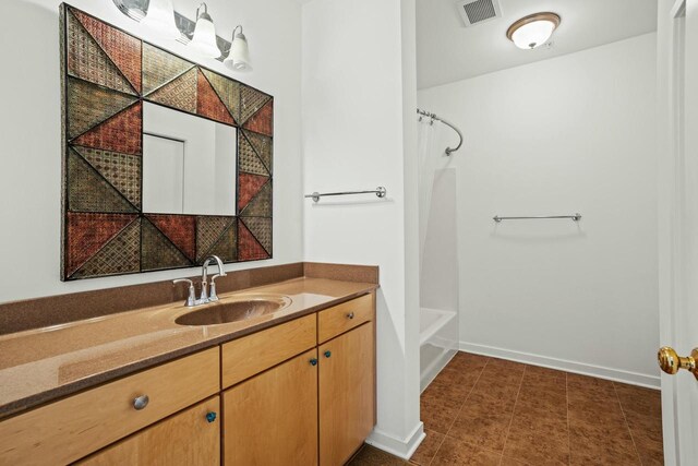 bathroom with tile patterned flooring, visible vents, baseboards, shower / tub combo, and vanity