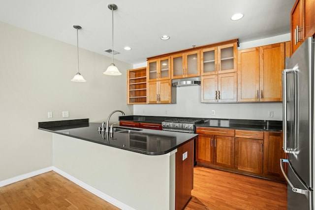 kitchen with visible vents, under cabinet range hood, a peninsula, stainless steel appliances, and a sink