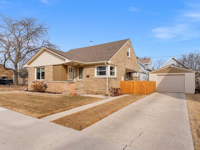 view of front of property featuring fence, driveway, an outdoor structure, a garage, and brick siding