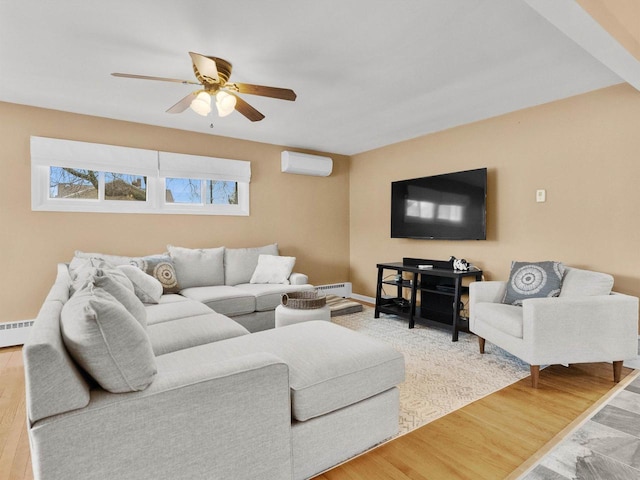 living room with a ceiling fan, wood finished floors, a baseboard radiator, and a wall mounted AC