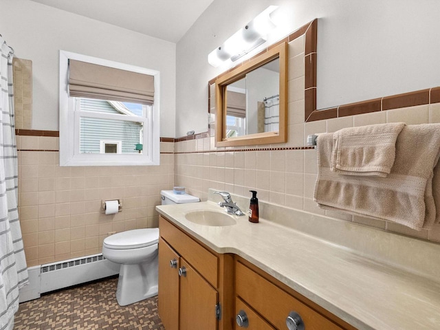 bathroom with vanity, a wainscoted wall, a baseboard heating unit, tile walls, and toilet