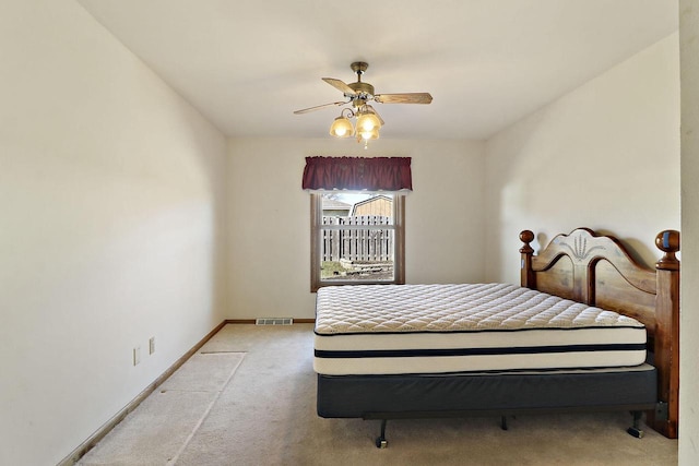 bedroom featuring ceiling fan, baseboards, visible vents, and light carpet