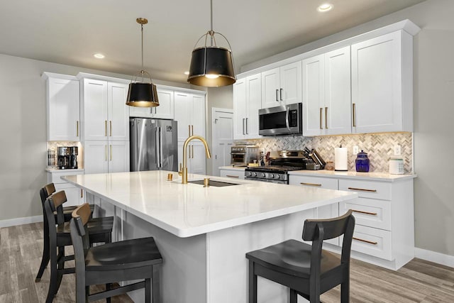 kitchen with a sink, stainless steel appliances, backsplash, and a breakfast bar area