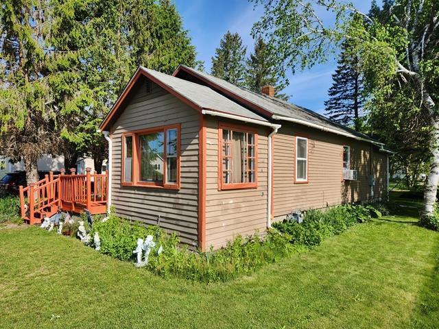 view of home's exterior featuring a wooden deck, a lawn, and a chimney