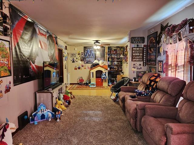 carpeted living area featuring ceiling fan