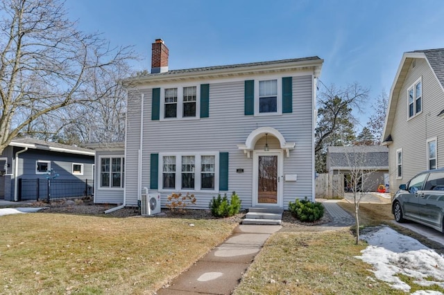 view of front of property featuring a front yard, ac unit, fence, and a chimney