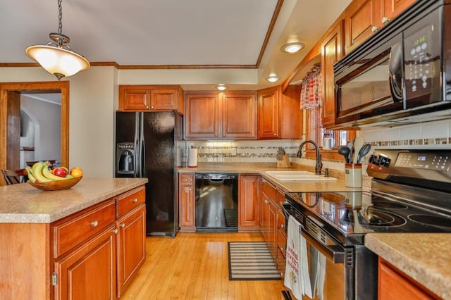 kitchen featuring black appliances, light wood-style flooring, a sink, backsplash, and light countertops