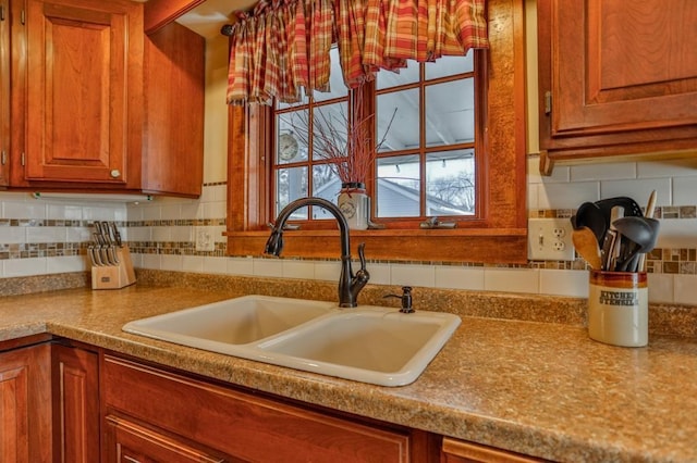 kitchen featuring tasteful backsplash, brown cabinets, and a sink