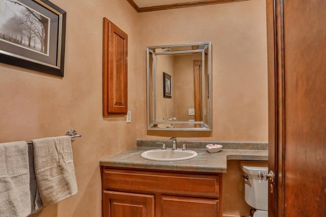 bathroom featuring vanity, toilet, and ornamental molding