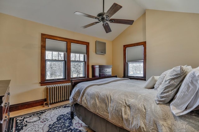 bedroom with baseboards, radiator heating unit, lofted ceiling, wood finished floors, and a ceiling fan