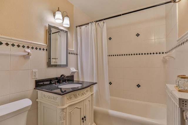 bathroom featuring tile walls, vanity, toilet, and shower / tub combo