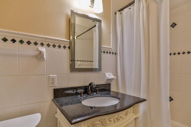 full bath featuring a shower with shower curtain, toilet, tile walls, and vanity