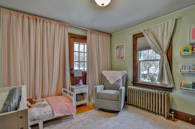 sitting room with plenty of natural light, radiator, baseboards, and wood finished floors