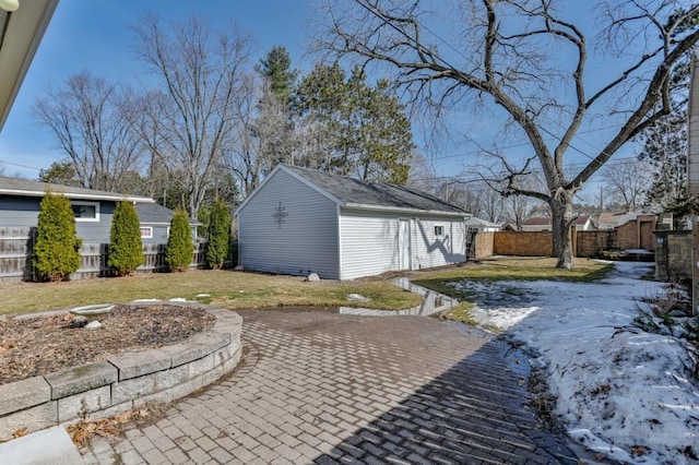 exterior space featuring an outdoor structure, fence, a lawn, and a patio area