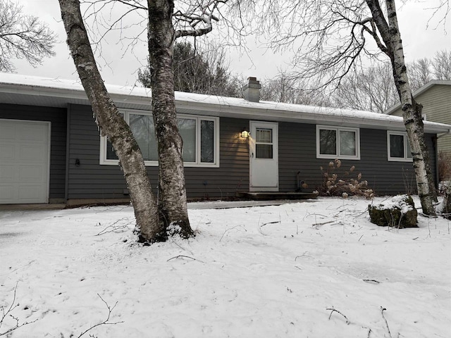 view of front of home featuring a chimney and a garage