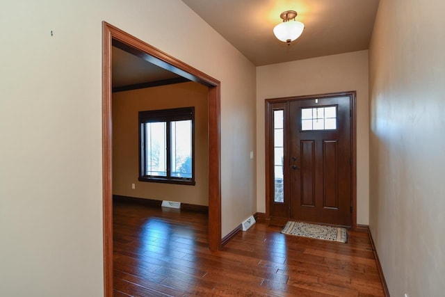 entryway with dark wood finished floors, visible vents, and baseboards