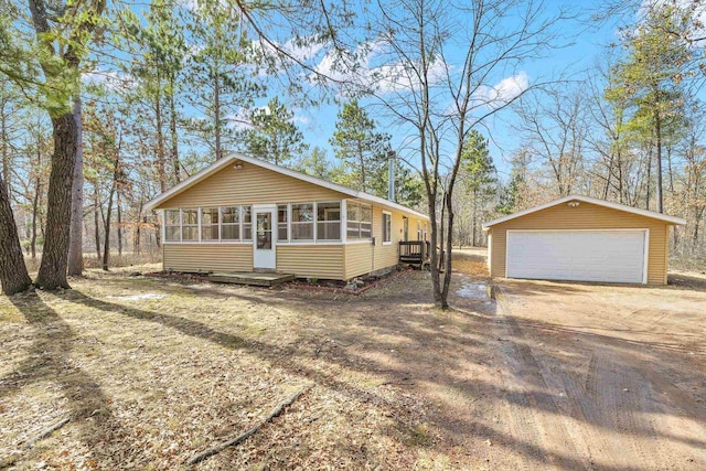 view of front of home featuring a garage, an outdoor structure, and a sunroom