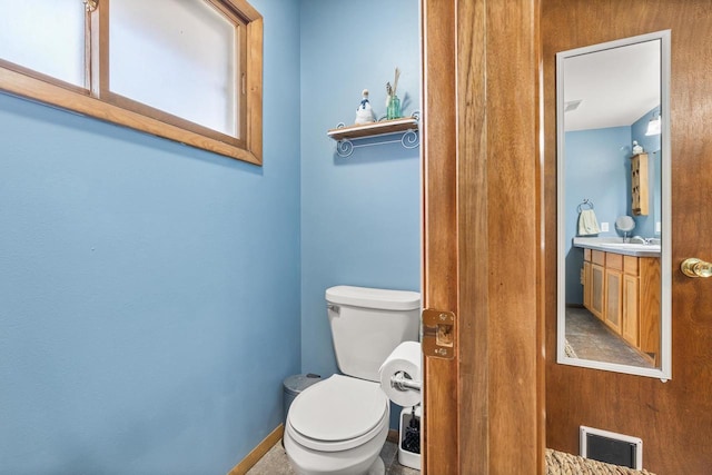 bathroom featuring visible vents, baseboards, toilet, and vanity