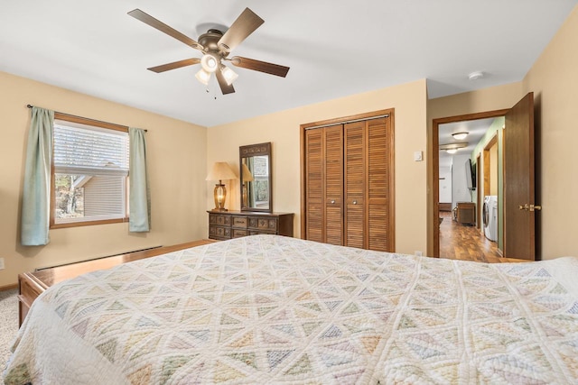 bedroom featuring a baseboard heating unit, independent washer and dryer, a closet, and ceiling fan