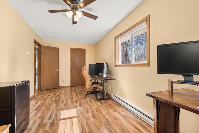 office area featuring a baseboard heating unit, baseboards, light wood-style floors, and ceiling fan