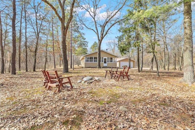 view of yard featuring a detached garage, an outbuilding, and a sunroom