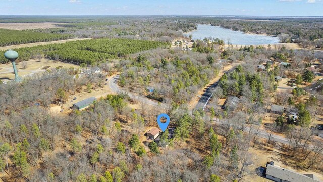 bird's eye view featuring a wooded view and a water view