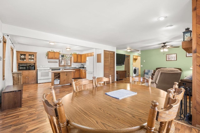 dining space featuring light wood-style floors, washer / dryer, and ceiling fan