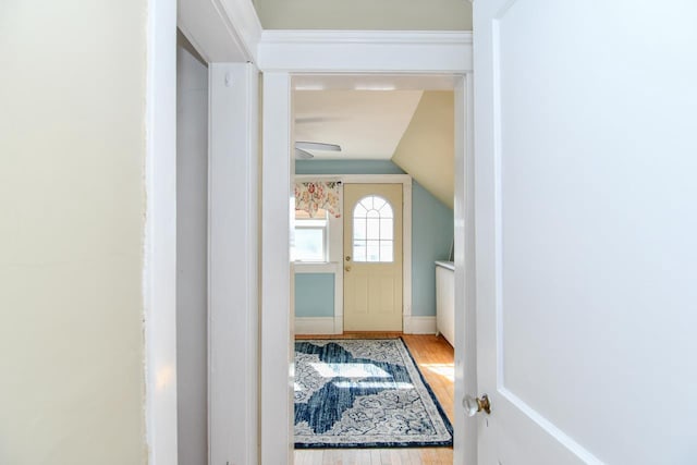 interior space with baseboards, lofted ceiling, and wood finished floors