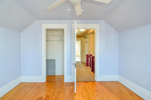 additional living space with ceiling fan, baseboards, lofted ceiling, and light wood-style flooring