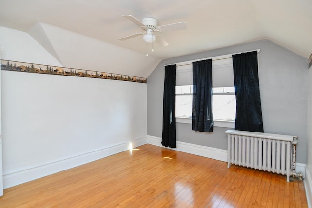 bonus room with lofted ceiling, radiator, light wood finished floors, baseboards, and ceiling fan