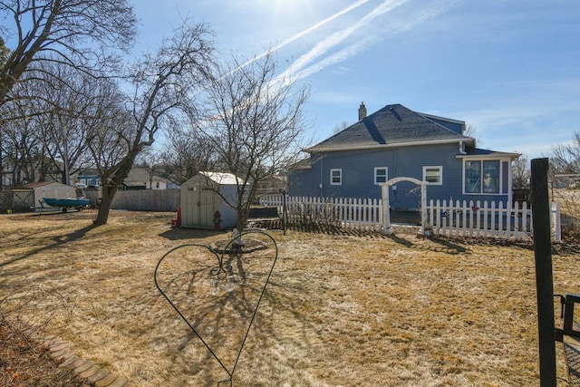 view of yard with an outbuilding, fence private yard, and a storage unit